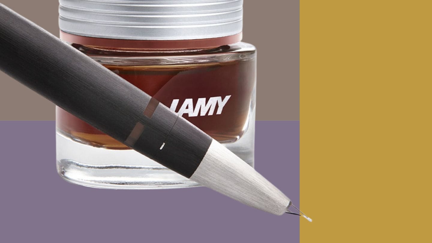 LAMY Fuellhalter 2000 und Tintenfass vor farbigem Hintergrund