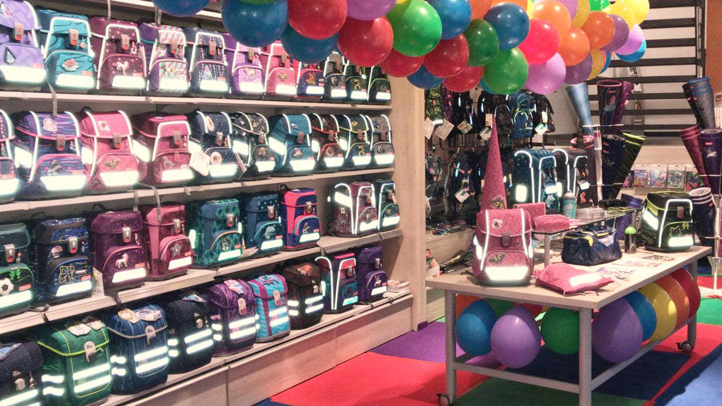 die grosse Schulranzen und Rucksackauswahl bei Koenig Plus in der Schulranzenwelt mit buntem Boden und Luftballons